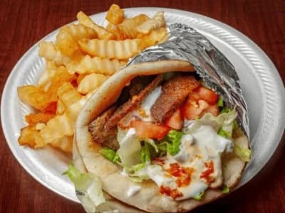 Lamb gyro pita with vegetables, tzatziki and fries