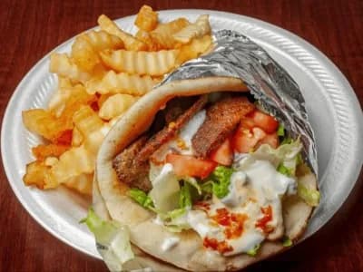 Lamb gyro pita with vegetables and tzatziki, pictured with fries
