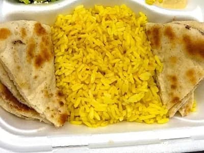 Seasoned yellow rice pictured with pita